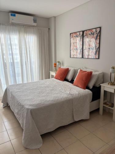 a bedroom with a large bed with two red pillows at Studios Montevideo in Buenos Aires