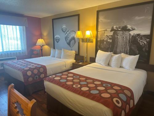 a hotel room with two beds and a painting on the wall at Super 8 by Wyndham Las Vegas in Las Vegas