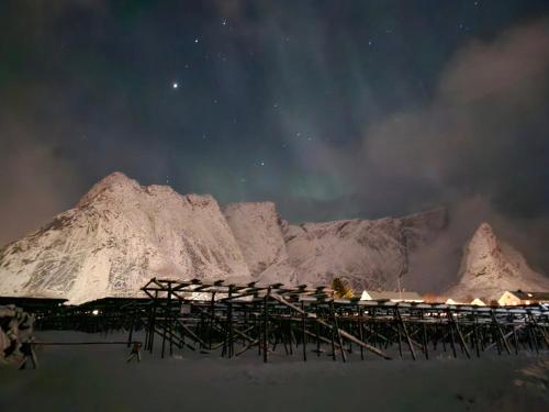 a night view of a pier with mountains in the background at Apartment at Lofoten. Mølnarodden. in Sund