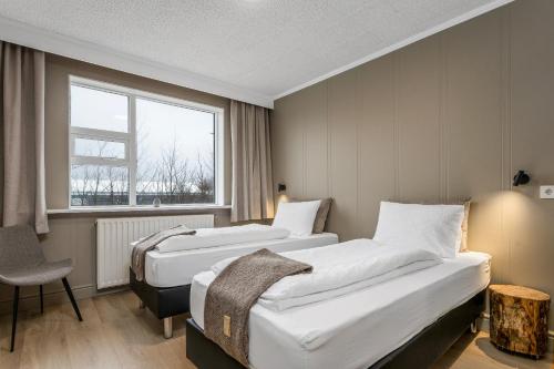 Una habitación de hotel con dos camas y una ventana. en Stracta Hotel Mosfell, en Hella