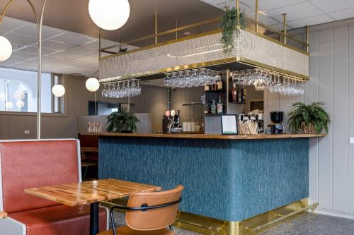 eine Bar in einem Restaurant mit einem Tisch und Stühlen in der Unterkunft Stracta Hotel Mosfell in Hella