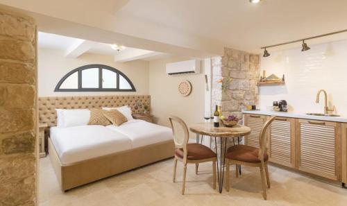 a bedroom with a bed and a table and a kitchen at המילטון 2 - Hamilton 2 in Safed