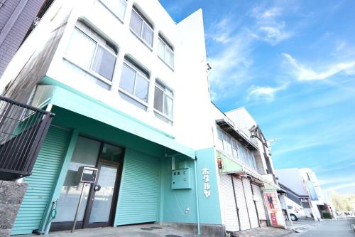 a blue and white building on a street at 南栄駅1分 3寝室 最大9名 キッチン付一棟貸し パーキング1分 Showa Retro Japanese House 1min Station Entire Home for 9 in Toyohashi