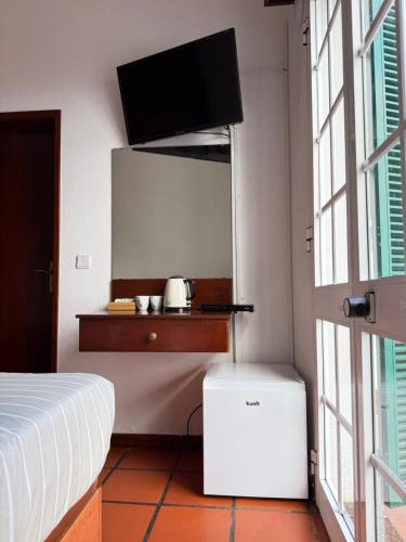 a bedroom with a bed and a tv on a wall at Beautiful Room in the montains in Estrela