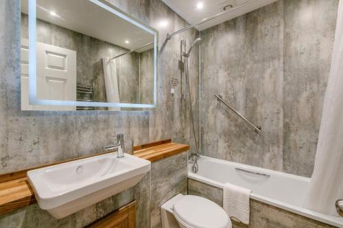 a bathroom with a sink and a toilet and a mirror at 2 Bed in Penzance oc-u34133 in Penzance