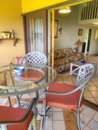 a living room with a glass table and chairs at Molokai Kepuhi Beach Gem in Kepuhi