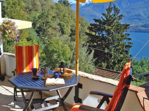 a table and chairs with an umbrella on a balcony at Asti in Gravedona