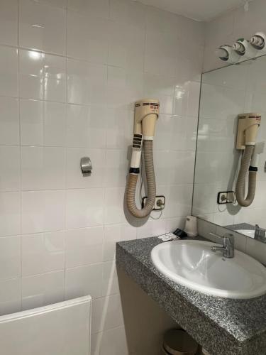 a bathroom with a sink and a phone on the wall at Hostal Ripollès in Ripoll