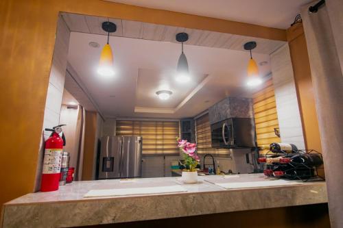 a kitchen with a counter with a refrigerator and lights at Classic Apartment at Tema Community 26 in Tema