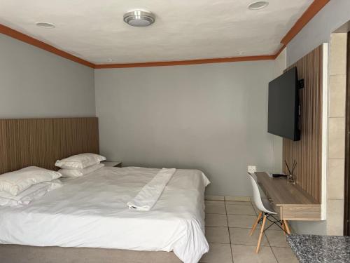 a bedroom with a bed and a television on the wall at Petron home in Kempton Park