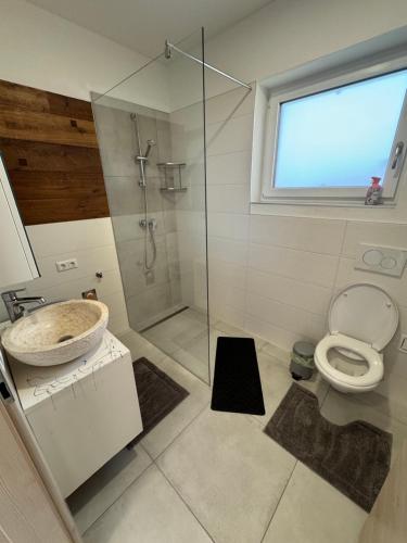 a bathroom with a toilet and a glass shower at Loft05 in Wankham