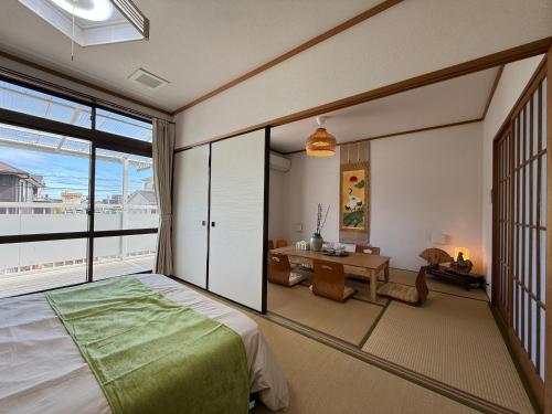 a bedroom with a bed and a desk and a window at 禅 宮島 一棟貸し 最大6名 ダブルベット3台 2階建の1棟貸しホテル in Hatsukaichi