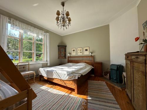 a bedroom with a bed and a chandelier at Lägenhet Strömsberg C in Strömsberg