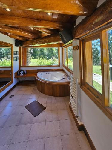 a large bathroom with a tub and windows at Rotui Luxury Village in San Martín de los Andes