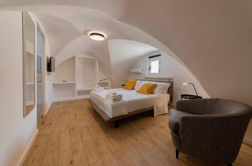 a bedroom with a bed and a chair at Suites7 in San Donato di Lecce