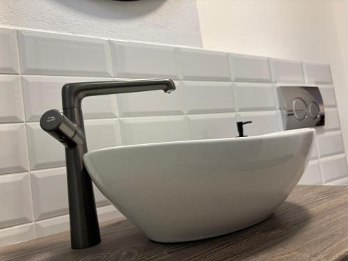 a white sink in a bathroom with a faucet at Clock in Gheorgheni