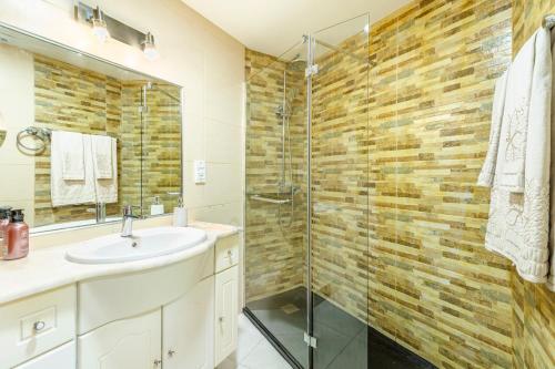 a bathroom with a sink and a glass shower at BoLina Caniço Center in Caniço