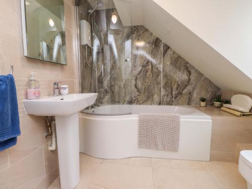 a bathroom with a sink and a bath tub at Fernlea in Morfa Nefyn