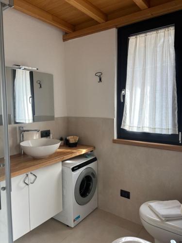 a bathroom with a washing machine and a sink at Spigolo Nord in Bellano