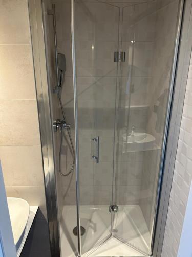 a shower with a glass door next to a toilet at Apartment Kysucká 1014 Top Floor & View in Košice