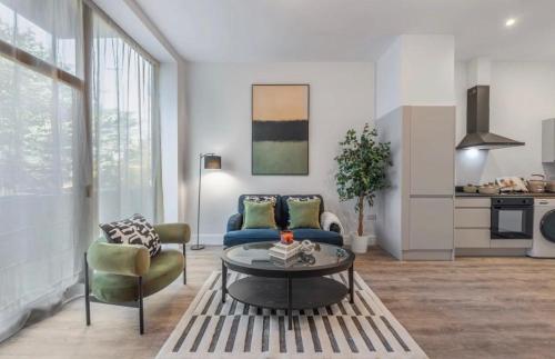 a living room with a couch and a table at Stylish 2 Bedroom Flat Near City Airport - Pet Friendly, Free WiFi & Free Parking in London