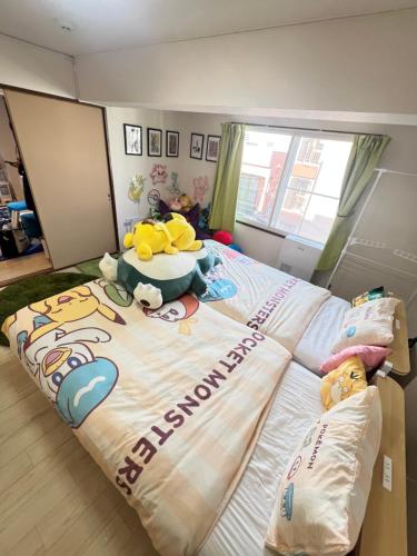 a large bed with a hello kitty blanket on it at ヴィオラ菊水 in Sapporo