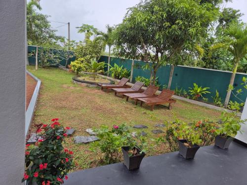 a group of benches in a garden with flowers at Villa Erika in Induruwa