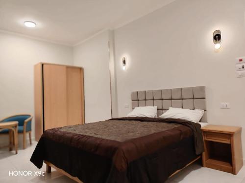 a bedroom with a large bed and a wooden table at SunShine in Quseir