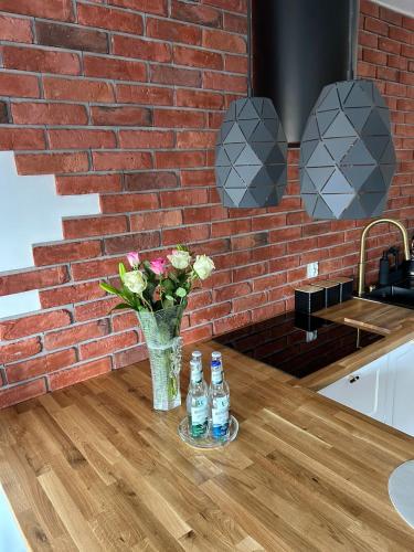 two bottles of water and a vase of flowers on a table at Apartament Bond in Szczawno-Zdrój