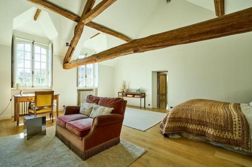 Charming house في Ury: غرفة نوم بها أريكة وسرير ومكتب