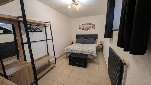 ein Schlafzimmer mit einem Bett mit blauen Kissen in der Unterkunft Le Maréchal in Dole