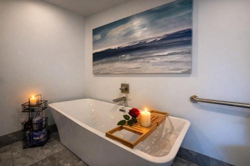 a bathroom with a tub with two candles and a painting at The 419 Ten-Room Boutique in Sandusky in Sandusky