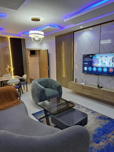 a living room with two chairs and a tv at Diolux Comfy Apartments in Sangotedo