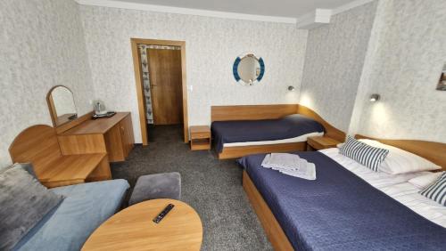 a hotel room with two beds and a mirror at Villa Atol in Niechorze