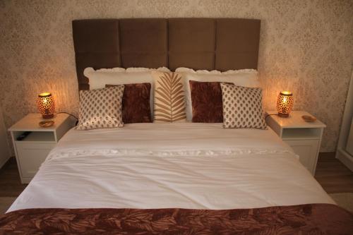 a bedroom with a large white bed with two lamps at Vila Prata Dourada 1 in Ferreira do Zêzere