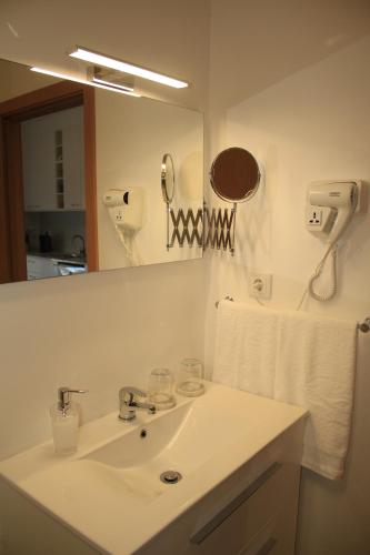 a bathroom with a sink and a mirror at Vila Prata Dourada 1 in Ferreira do Zêzere