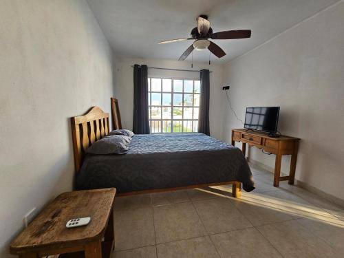 a bedroom with a bed and a ceiling fan at Las fincas Jiutepec in Jiutepec