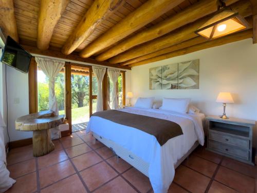 a bedroom with a bed and a wooden ceiling at Rotui Luxury Village in San Martín de los Andes