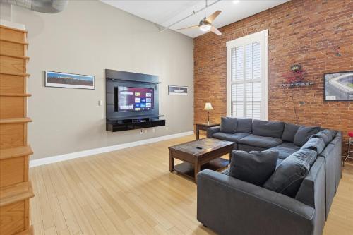a living room with a couch and a tv at 1800 Sq Ft Loft Downtown Near Convention Center in Indianapolis