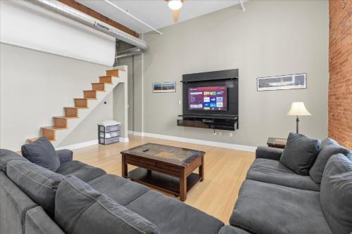 a living room with a couch and a tv at 1800 Sq Ft Loft Downtown Near Convention Center in Indianapolis