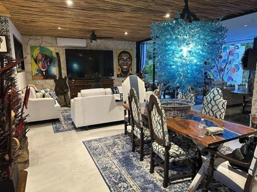 a living room with a table and chairs and a tv at Casa Azul-Xpuha, Tulum, Mexico in Xpu Ha