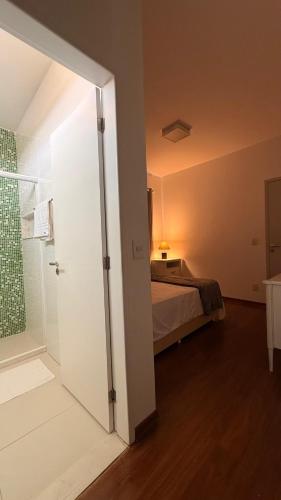 a bedroom with a bed and a sliding glass door at Pousada Casa de Praia in Marechal Deodoro