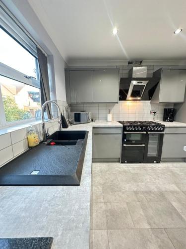 a large kitchen with a sink and a stove at Contractors Home - 4 Bedroom Long Stays Welcome - Barnsley in Shafton