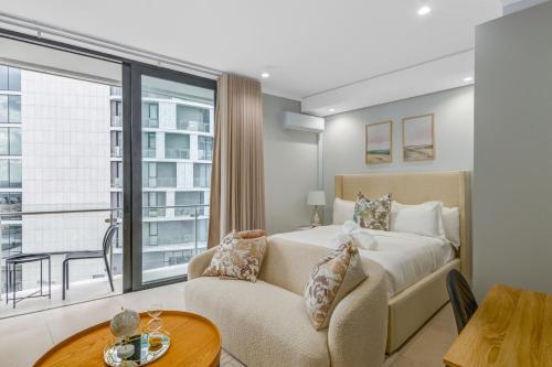 a bedroom with a bed and a couch and a window at Solitude Studio Apartment, Ellipse, Midrand in Midrand