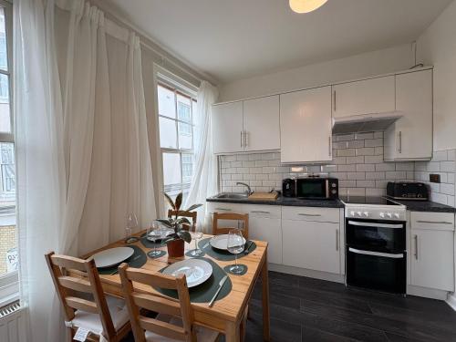 a kitchen with a table with two chairs and a dining room at The Pottergate Residence - Norwich Lanes in Norwich
