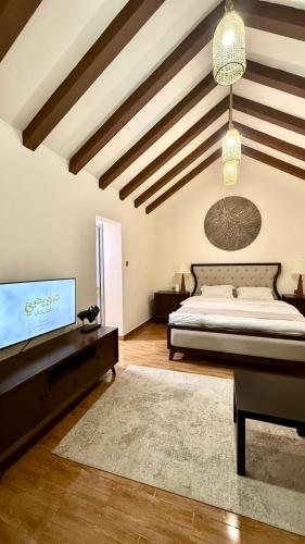 استراحة ريف حتا في حتا: غرفة نوم كبيرة بها سرير وجهاز تلفزيون