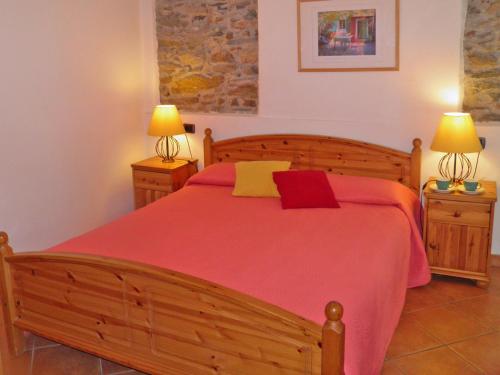 a bedroom with a bed with a red blanket and two lamps at Barolo in Gravedona