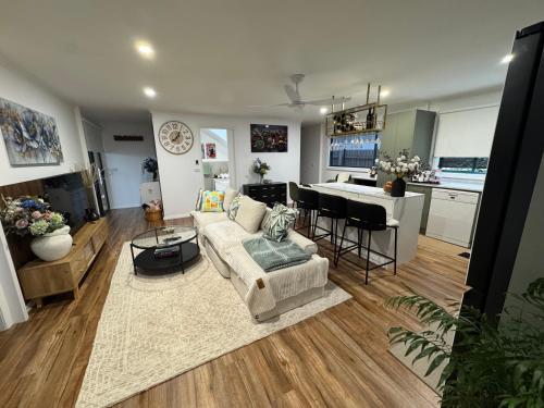 a living room and kitchen with a couch and a table at Brigidas Guest House in Bairnsdale