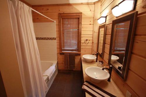 a bathroom with two sinks and a toilet and a tub at Whitewater Cottage & RV Resort in Foresters Falls