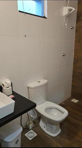 a bathroom with a white toilet and a sink at JMS Refuge in Pirapora